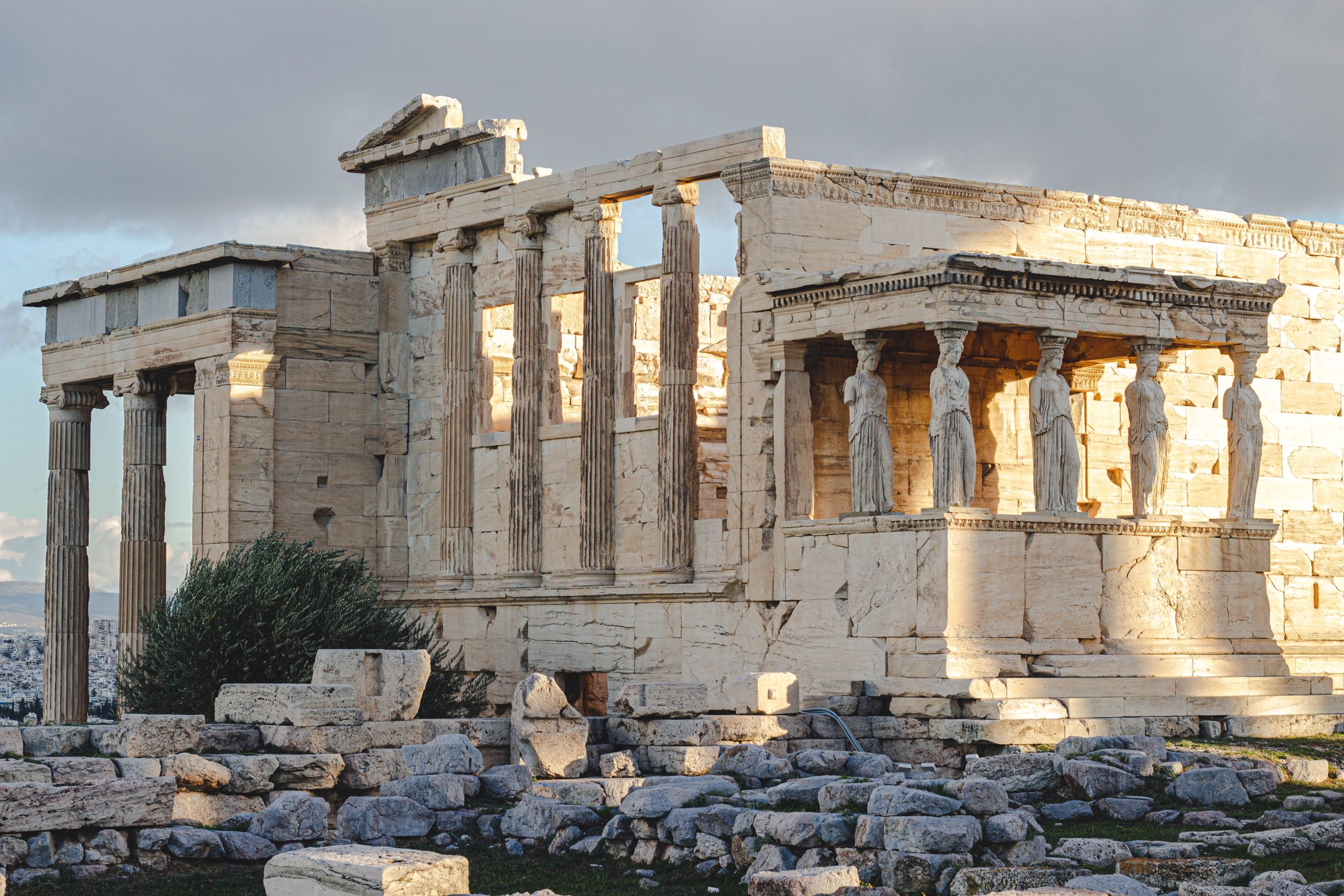 Ancient Erechtheion temple with caryatids at the Acropolis in Athens, Greece, illuminated by sunlight.